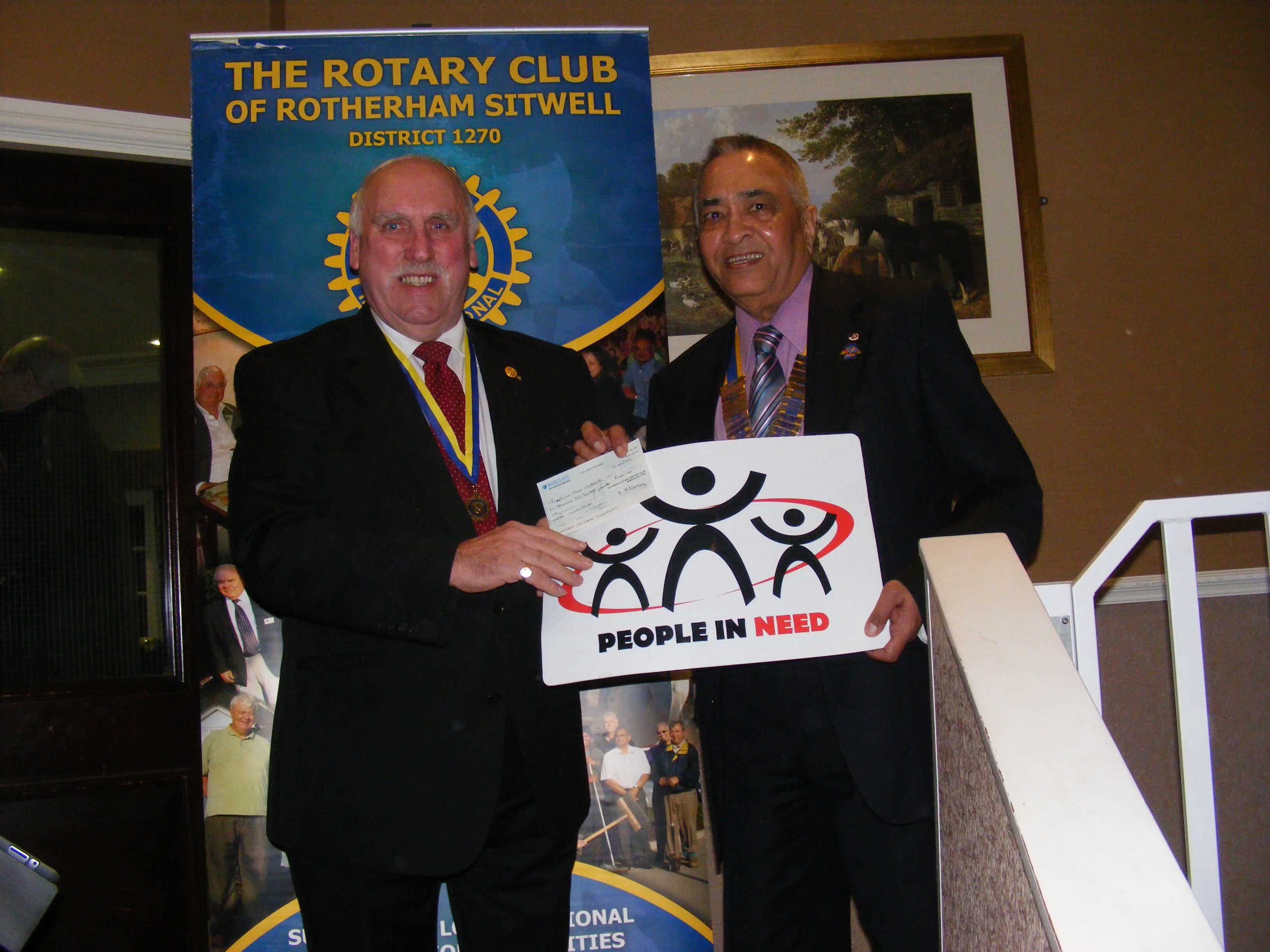 President Yogesh presents a cheque for £1200 to Joe Walker of People in Need Worldwide 